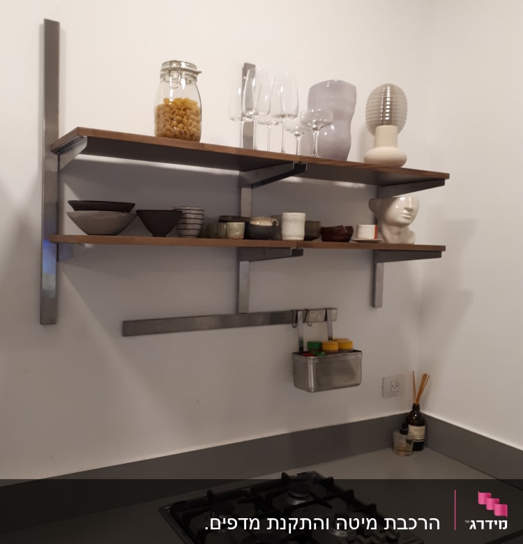 מדף עץ עם תומכים ממתכת מותקן על הקיר